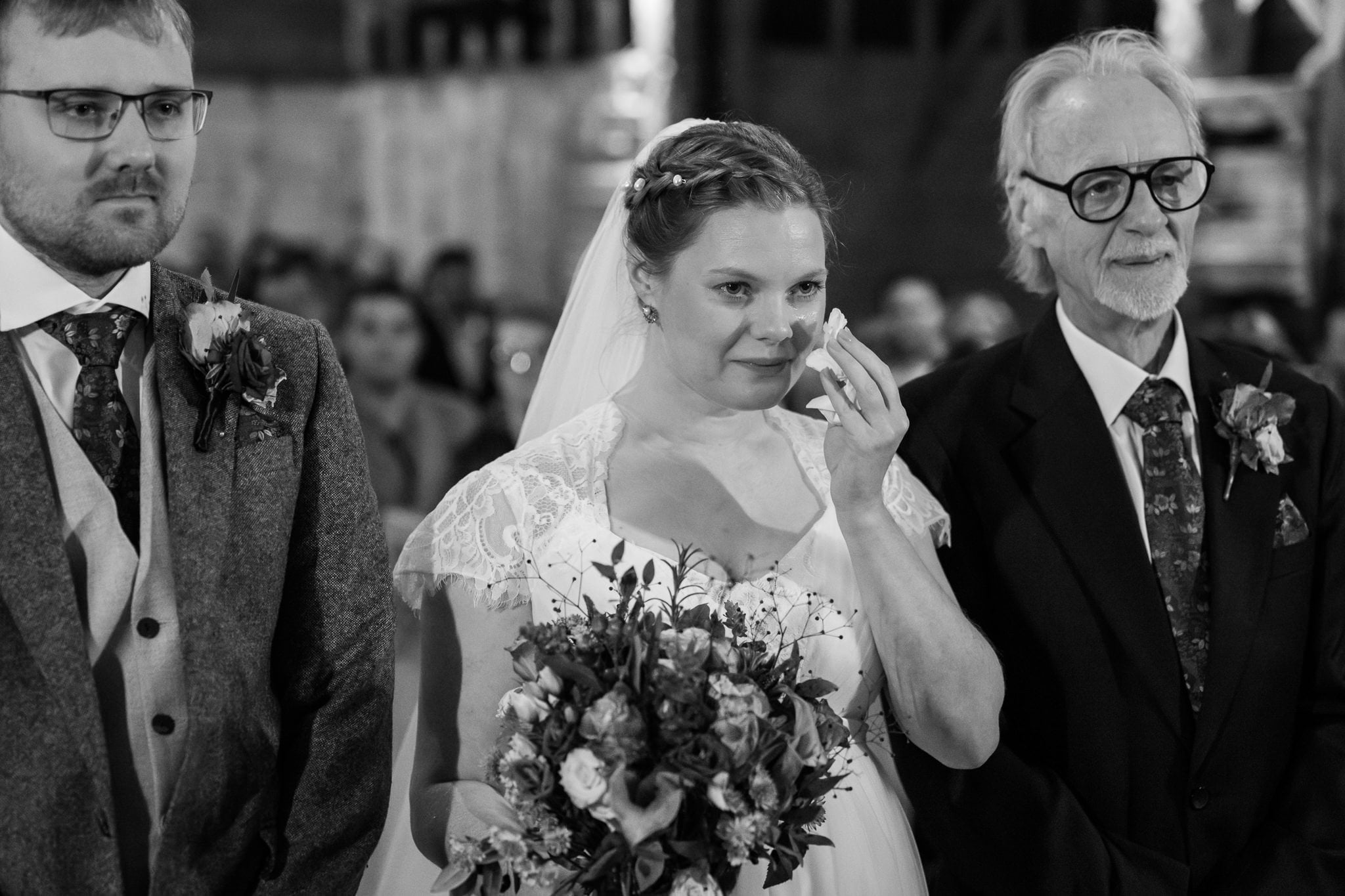 A bride walks down the aisle with her father.