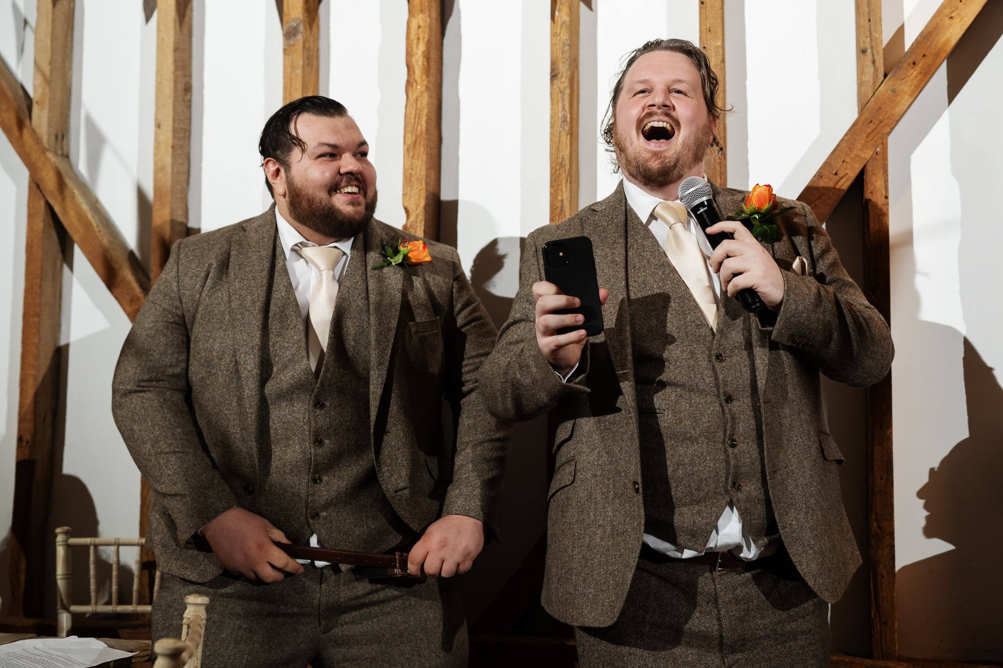 Two men in suits with microphones in front of them.
