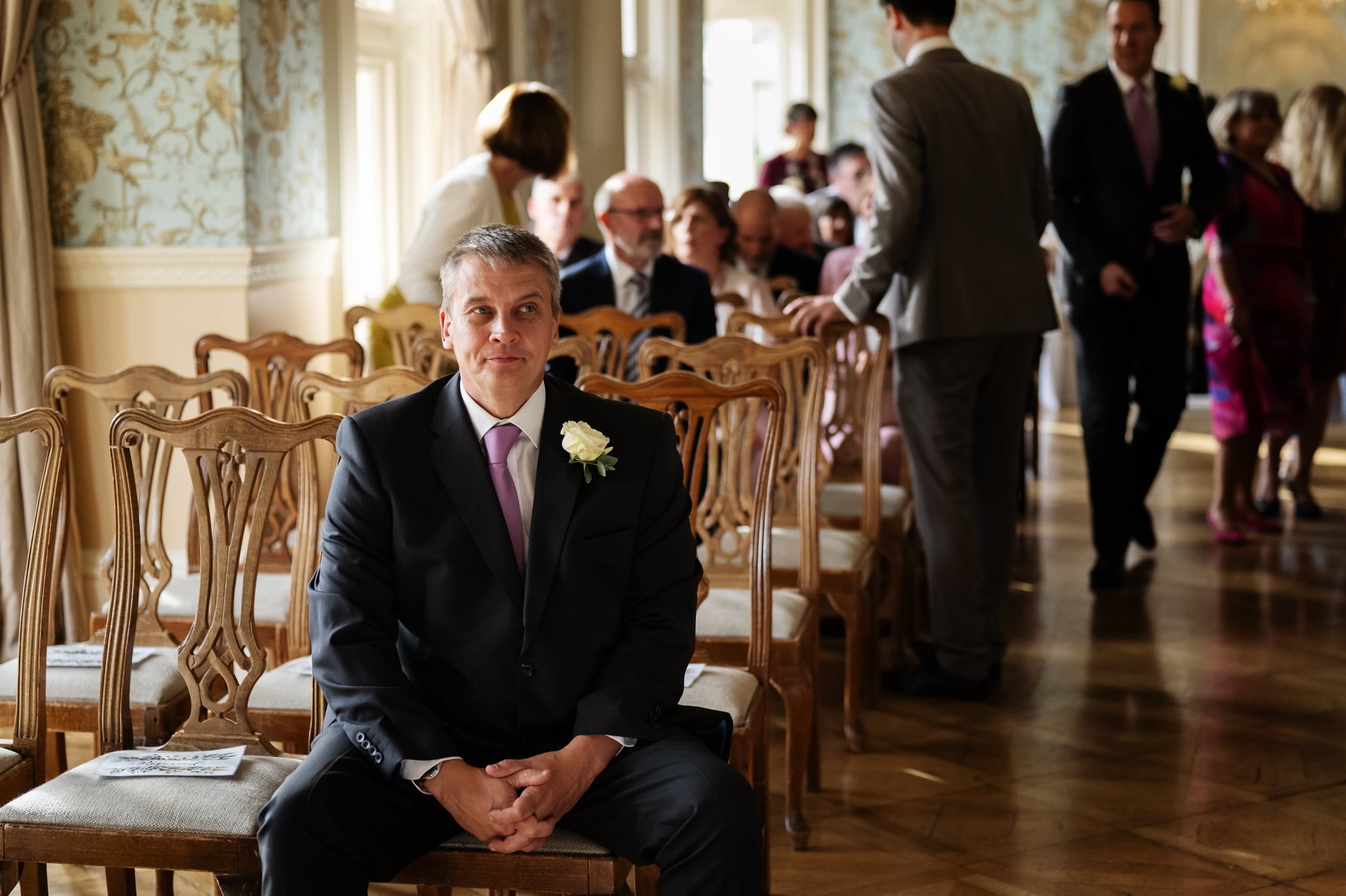 A man in a suit sitting in a chair.