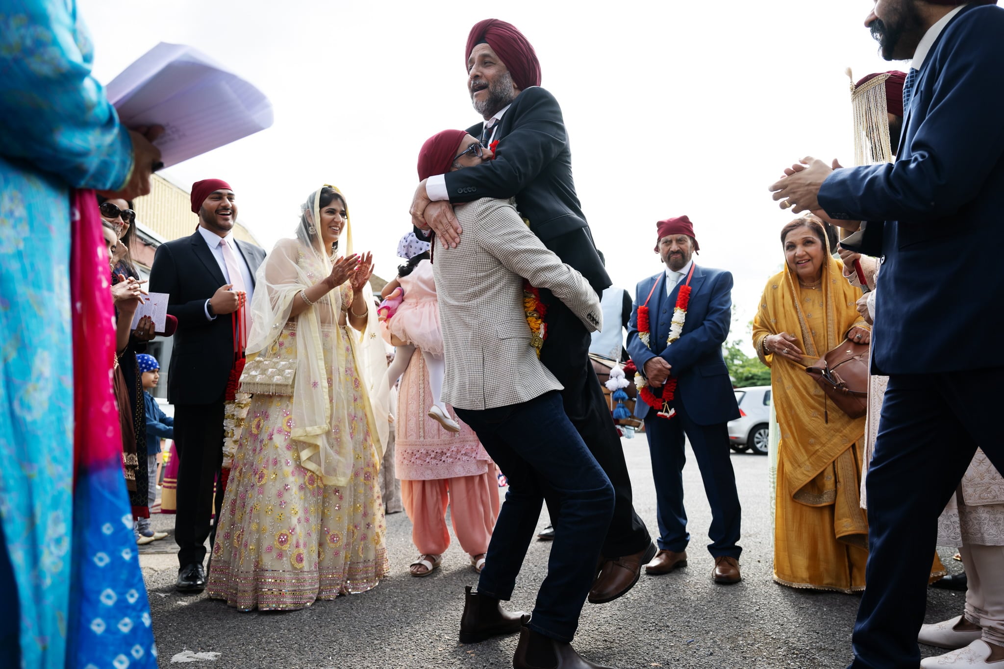 A man in a turban is hugging a man in a turban.