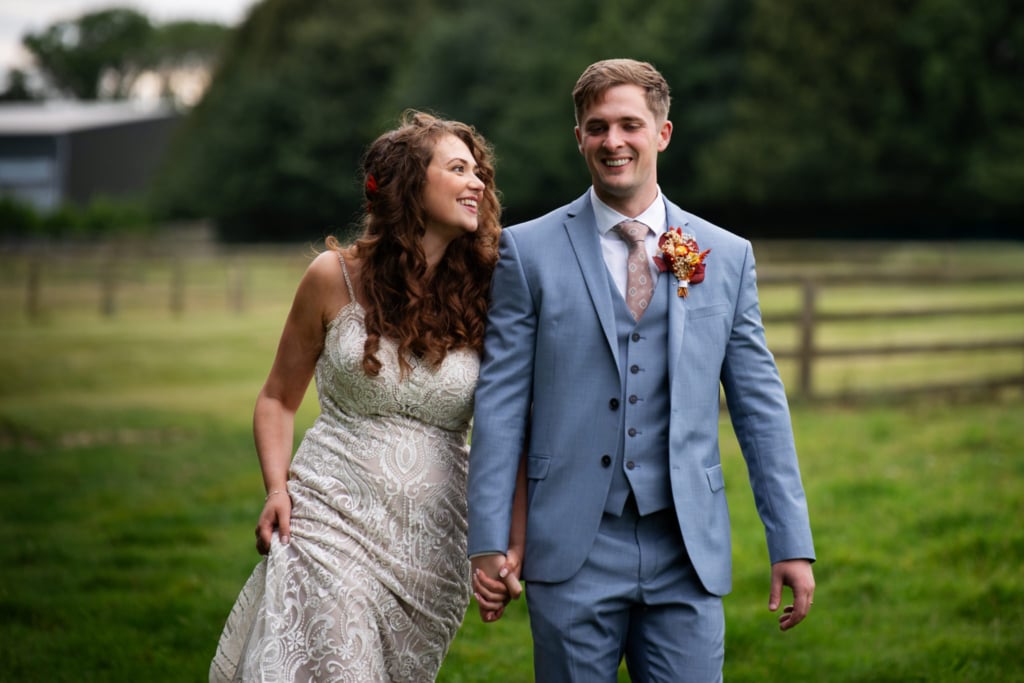 Bride and a groom walking in the grounds of Notley Tythe Barn