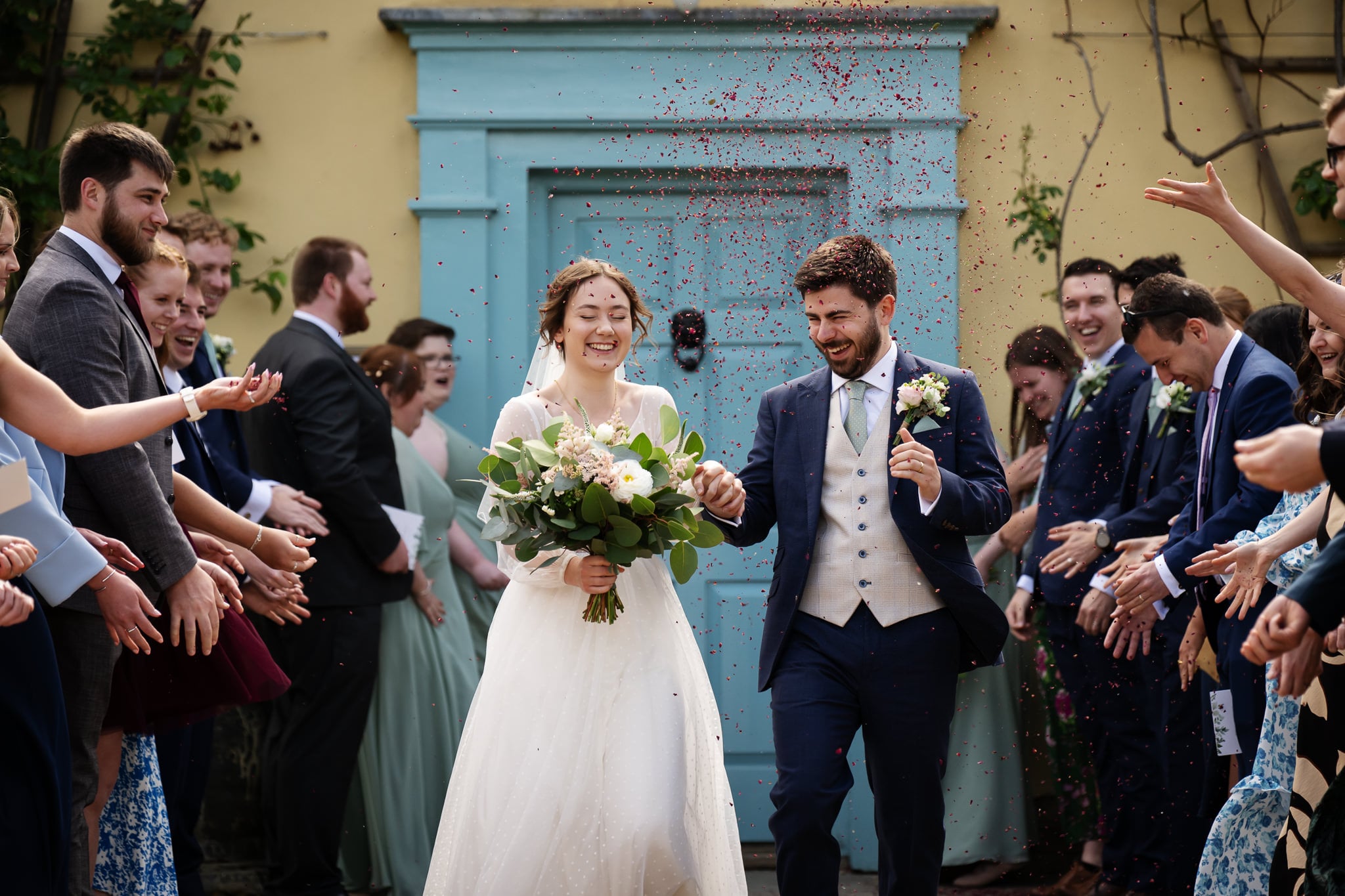 Bride and groom walking through confetti at South Farm