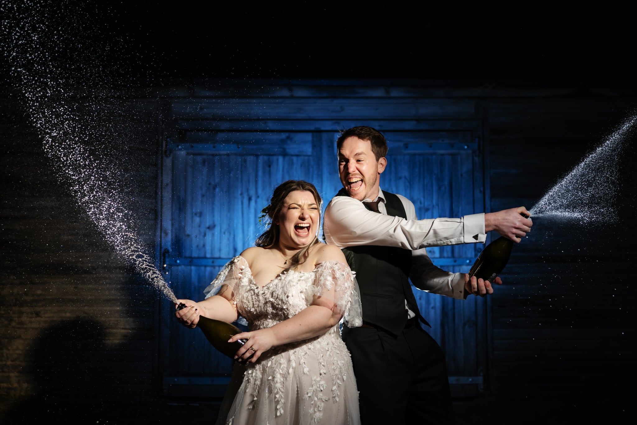 The bride and groom spray champagne at their Stratton Court Barn wedding
